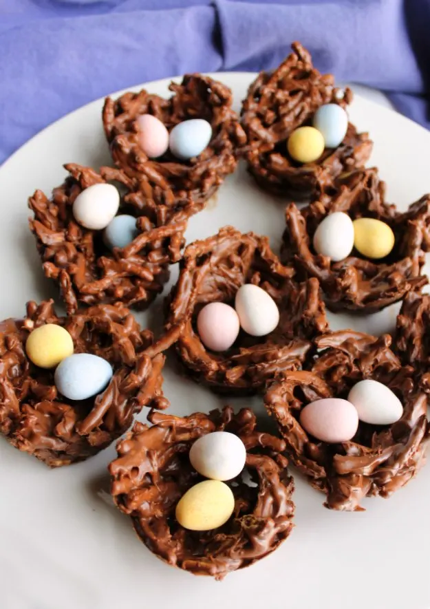 Serving plate filled with chocolate bird nest treats with cadbury mini eggs inside.