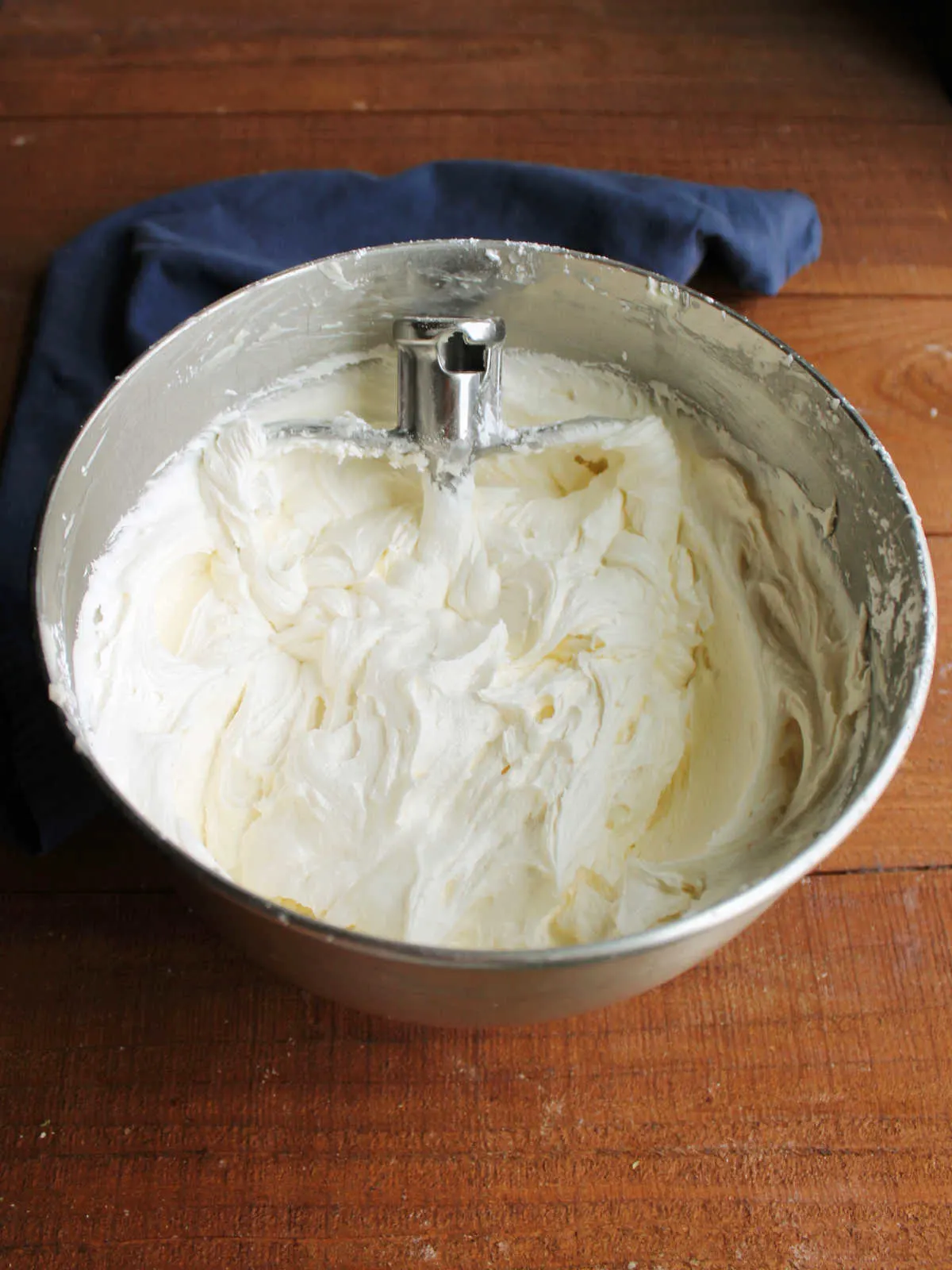 Mixer bowl of fluffy white buttercream frosting, ready to be used.