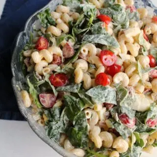 big bowl of pasta salad with bacon, spinach, tomatoes, avocadoes and eggs