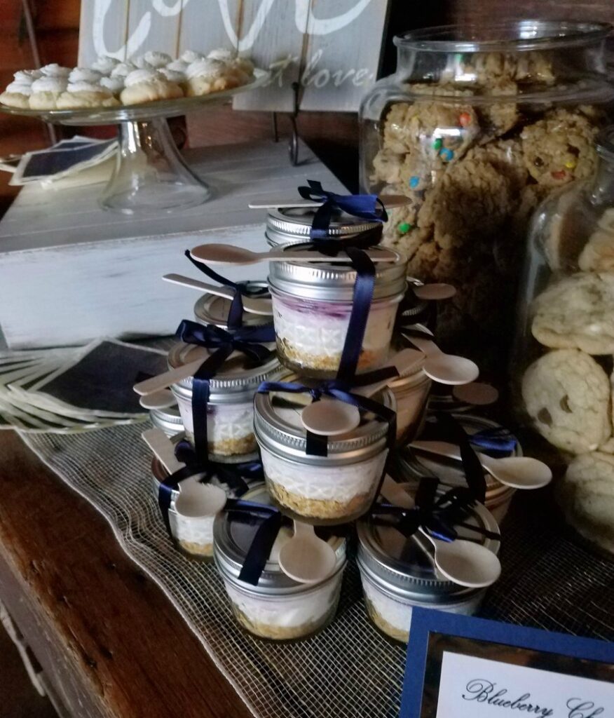 stack of lemon blueberry cheesecake jars with navy ribbon and bamboo spoons