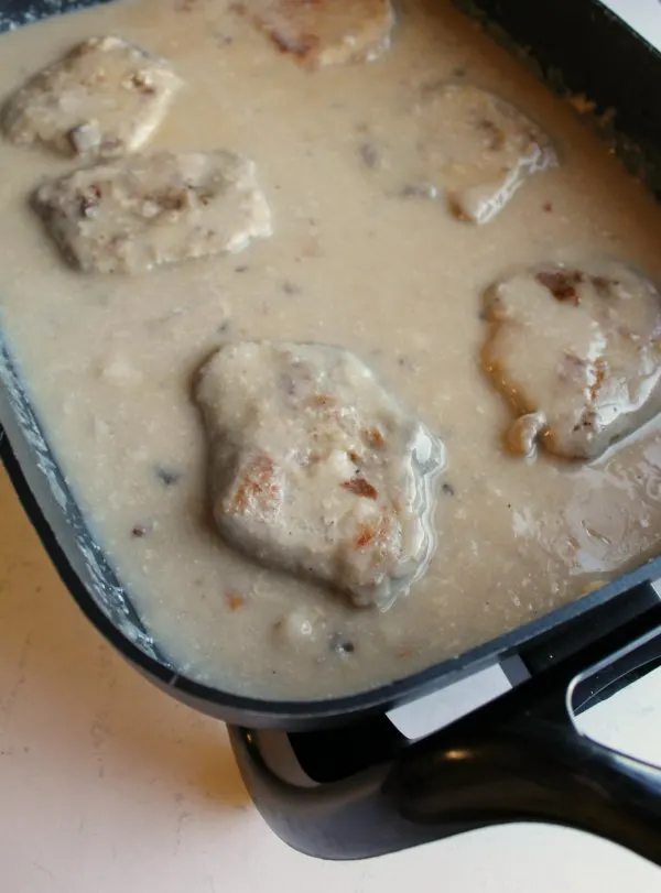 pork chops and mushroom soup gravy in electric skillet, ready to serve.