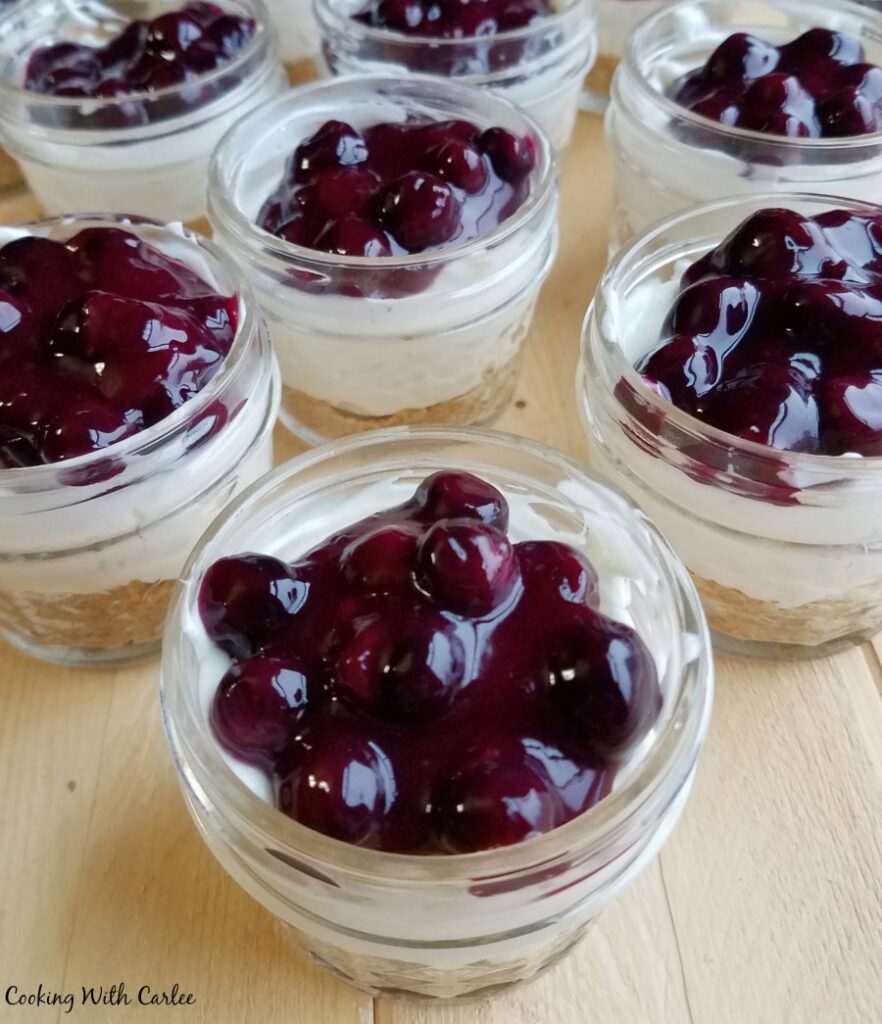 looking down on jars with lemon cheesecake and lots of blueberry topping