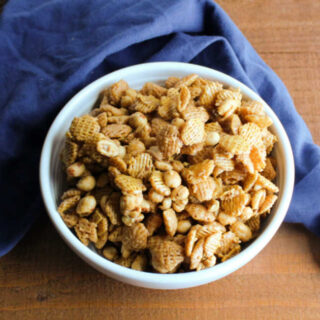 bowl of caramel cereal snack mix with peanuts.