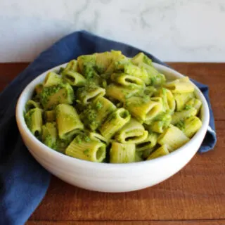 bowl of pasta coated in spinach and garlic scape pesto