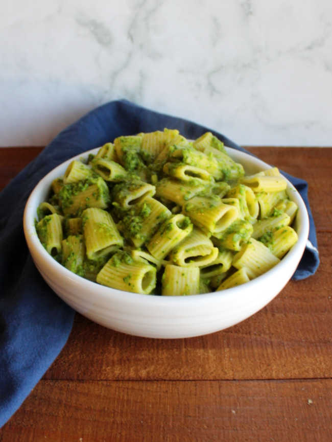 bowl of pasta coated in spinach and garlic scape pesto