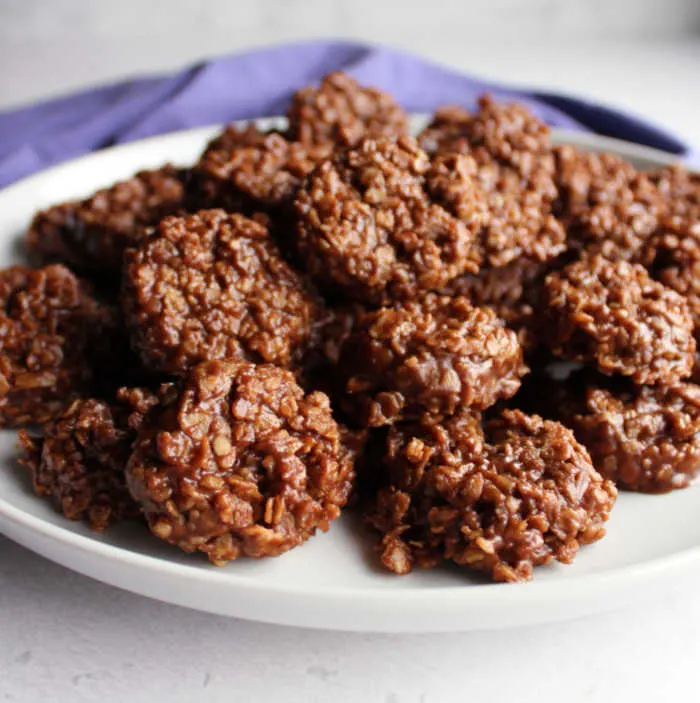 Pile of peanut butter and chocolate no bake oatmeal cookies on plate ready to eat.