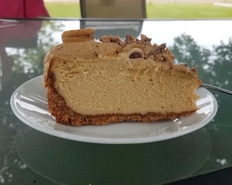 Slice of peanut butter cheesecake served at an outdoor party.