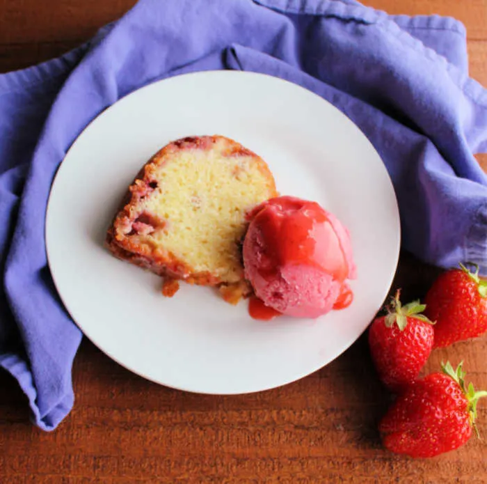 slice of strawberry and cream bundt cake with scoop of strawberry sherbet
