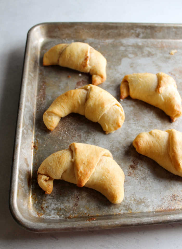 baking tray with sweet cinnamon and cream cheese stuffed crescent rolls fresh from the oven