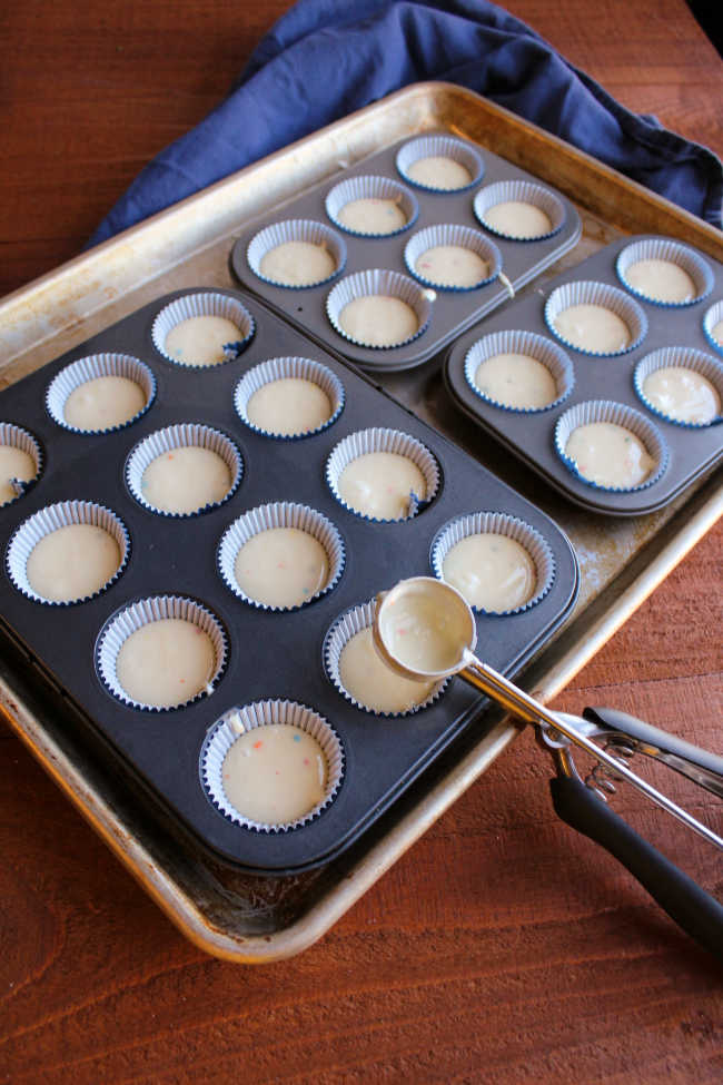 tray of mini cupcake tins filled with batter
