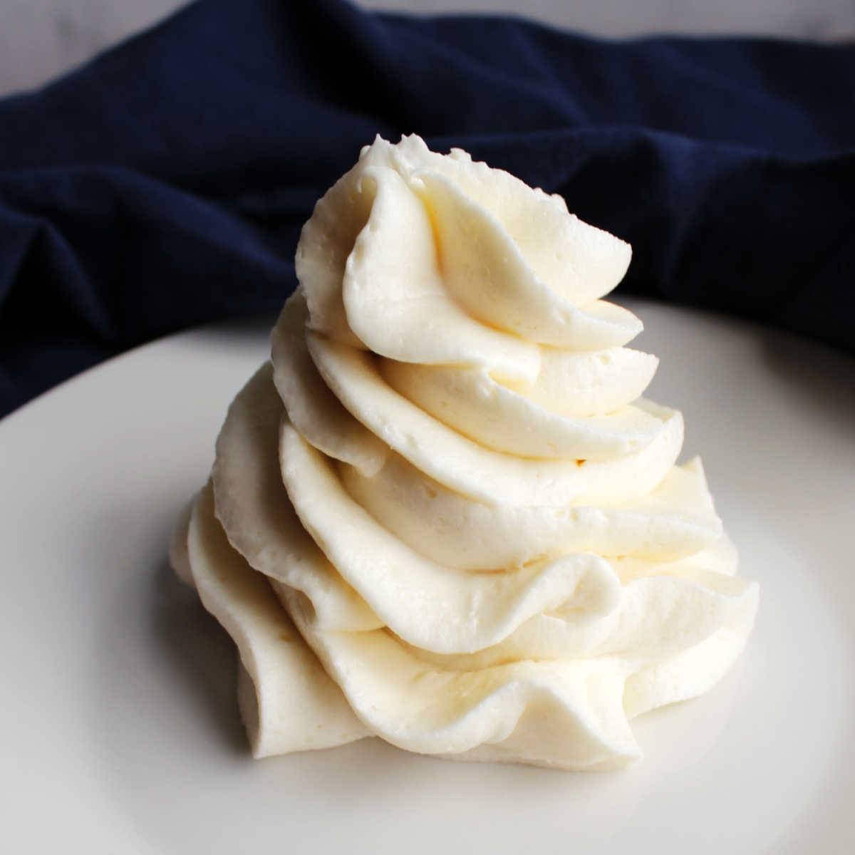 Piped swirl of fluffy cream cheese ermine frosting.