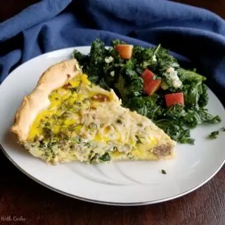 Slice of sausage and kale quinche served with a kale and apple salad on the side.