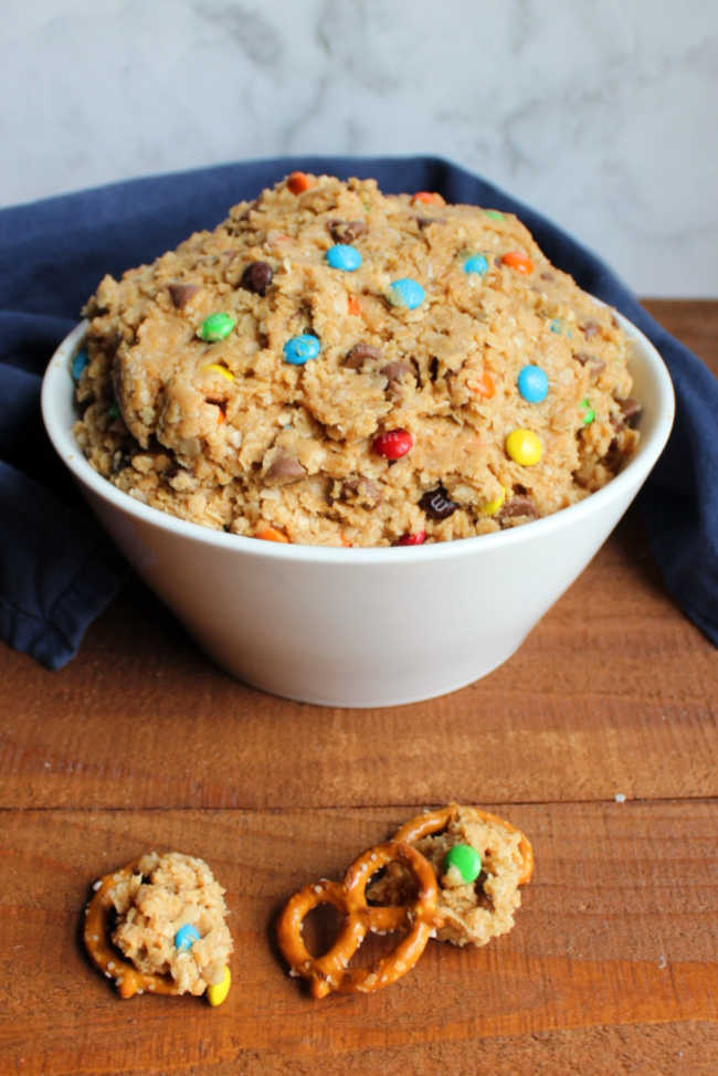 bowl of monster cookie dough dip with pretzels nearby