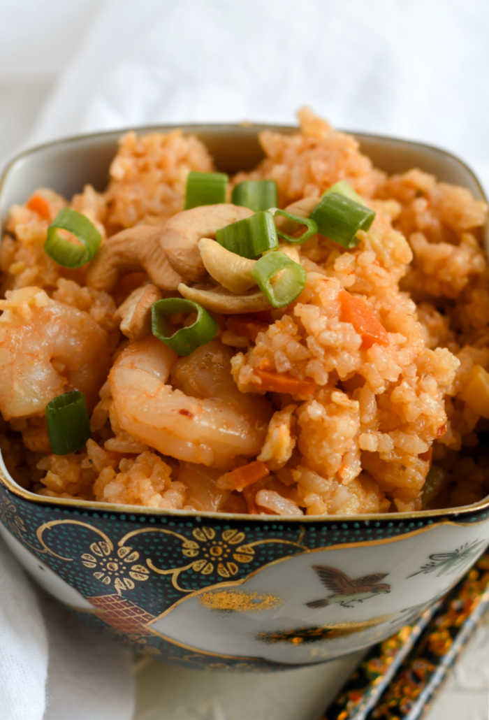 close up of shrimp fried rice with cashews and scallions on top