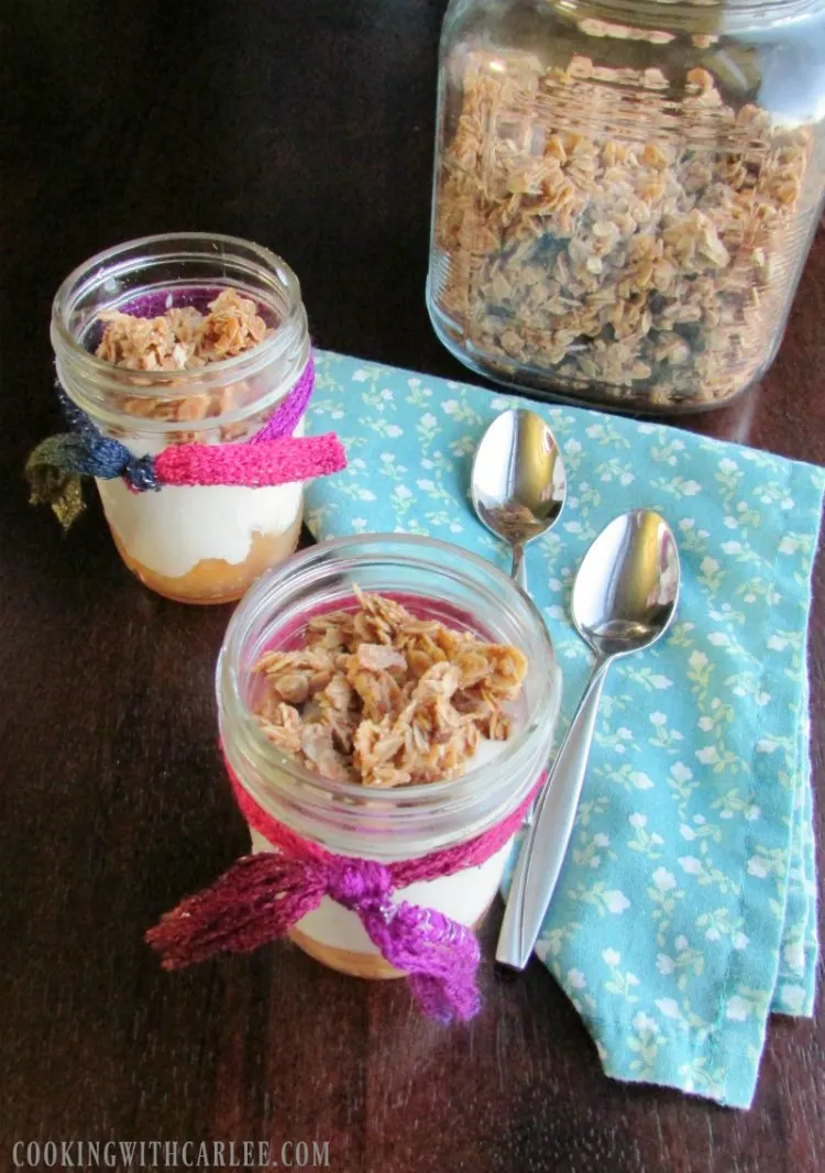 jars filled with apple pie filling, vanilla yogurt and topped with granola.