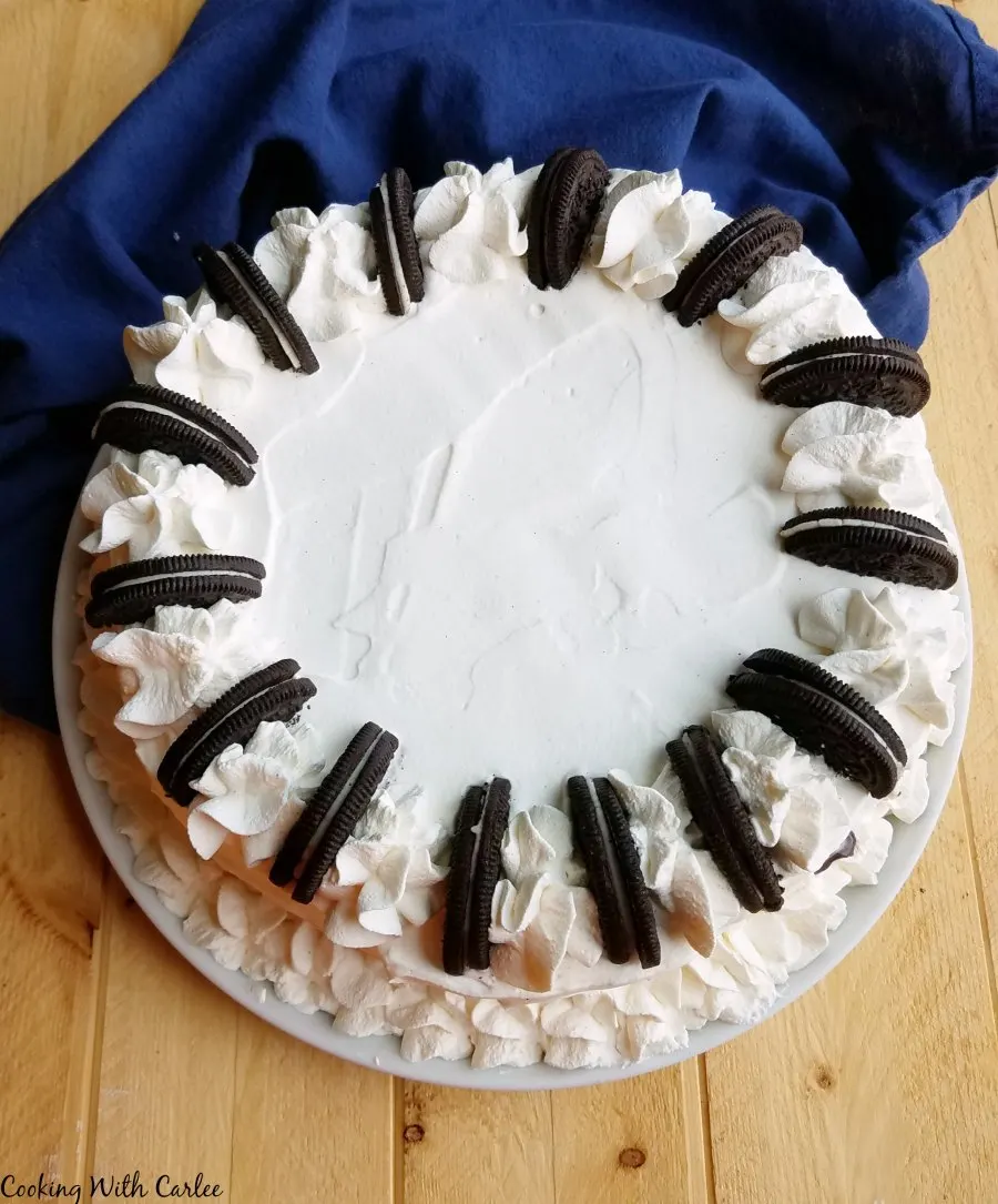 cake with piped whipped cream borders and cookie garnish