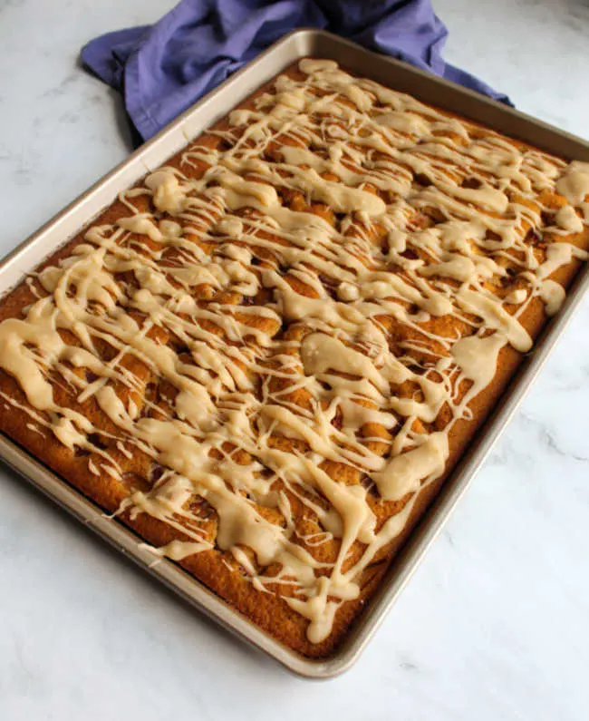 whole peach sheet cake drizzled with golden brown butter glaze.