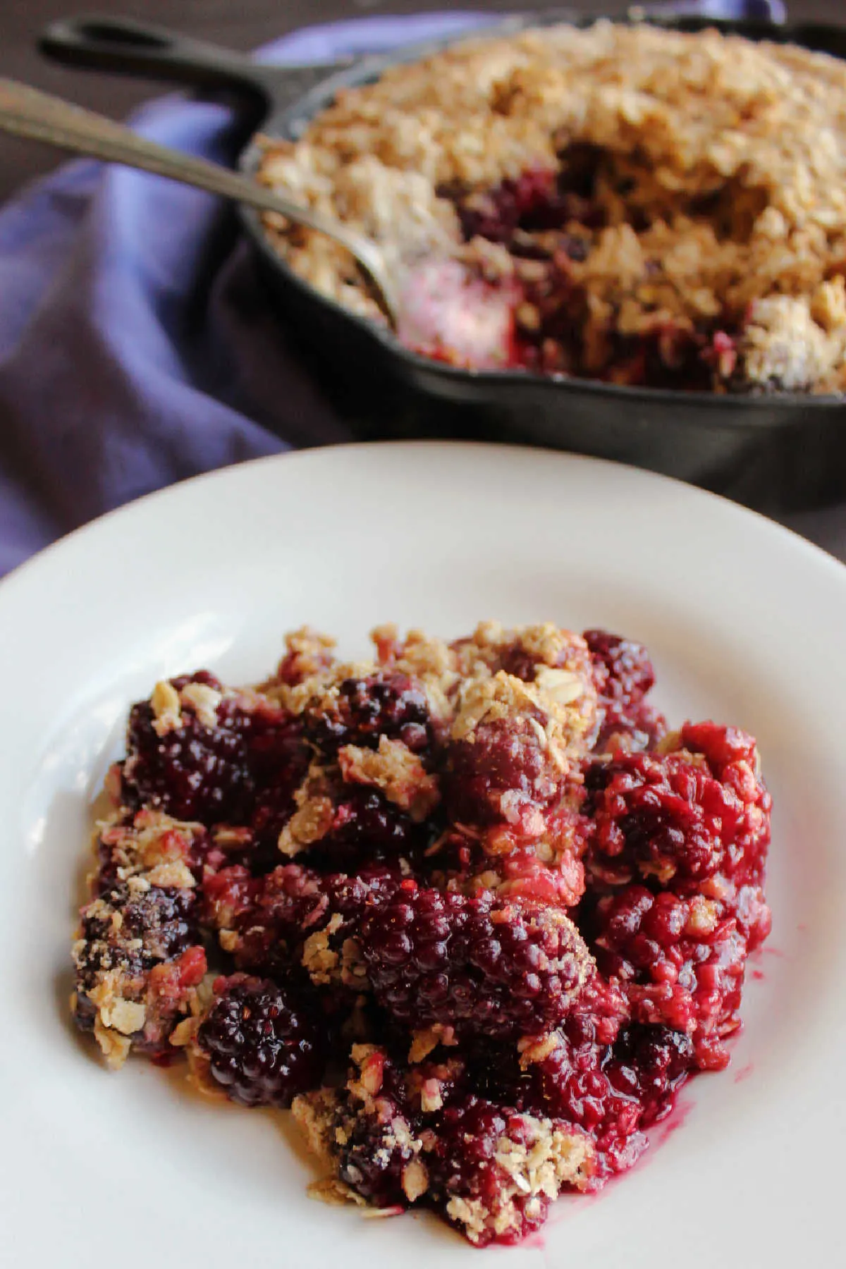 serving of blackberry crisp with oatmeal topping on plate.