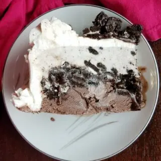 slice of ice cream cake with fudgy cookie crunch layer in the middle