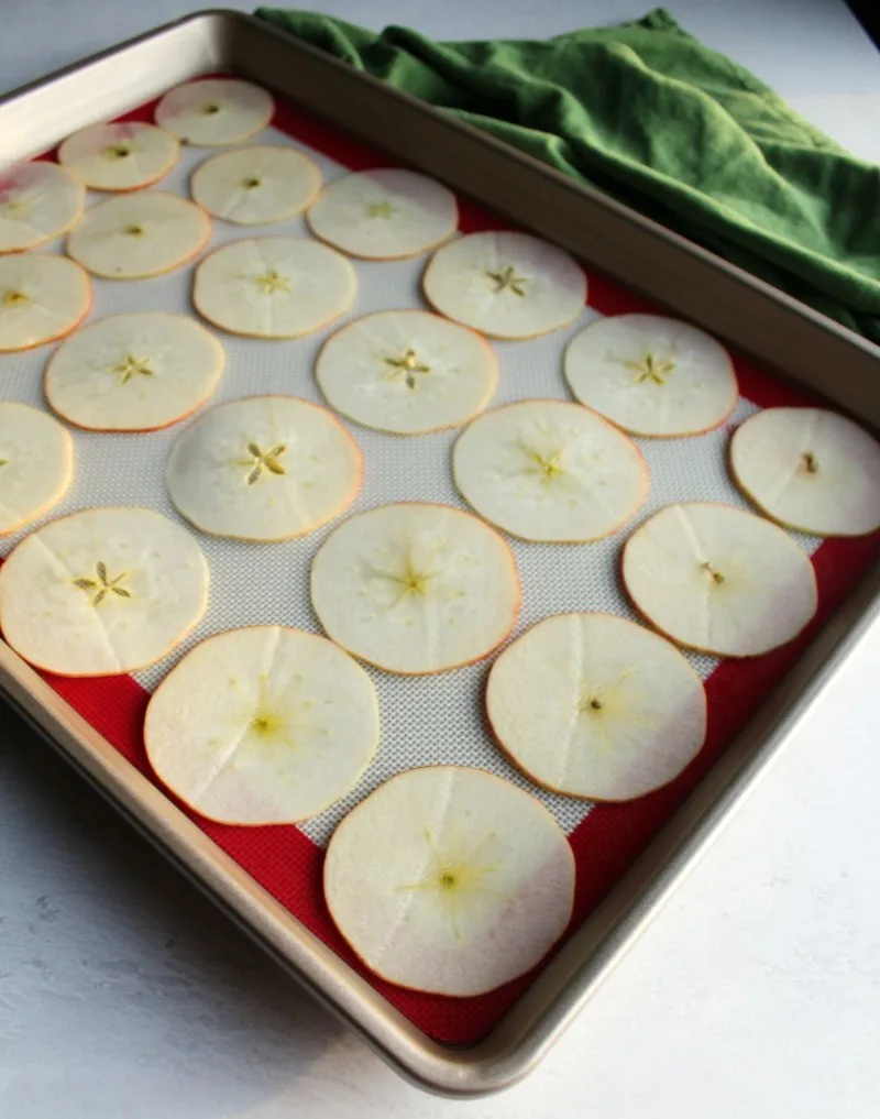 apple slices laid out on baking sheet ready to go in oven an be made into apple chips.
