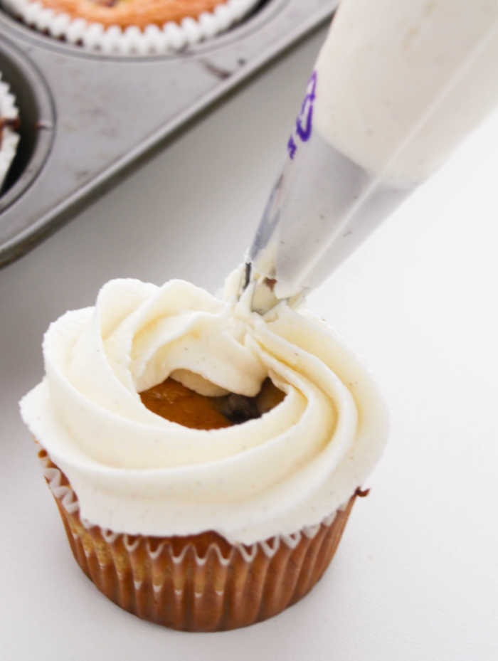 piping ring of frosting on top of cupcake