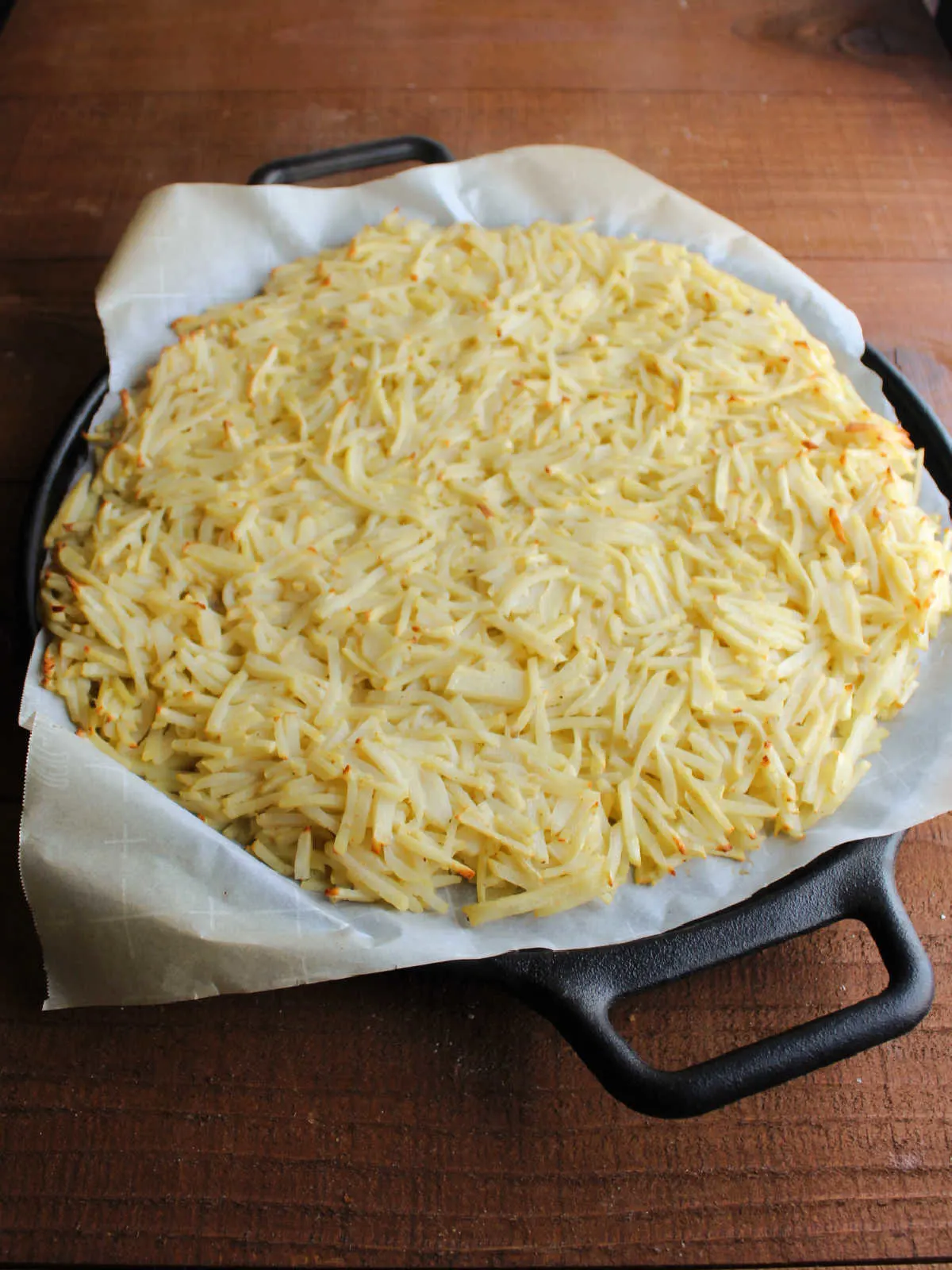 Hash brown pizza crust ready for toppings.