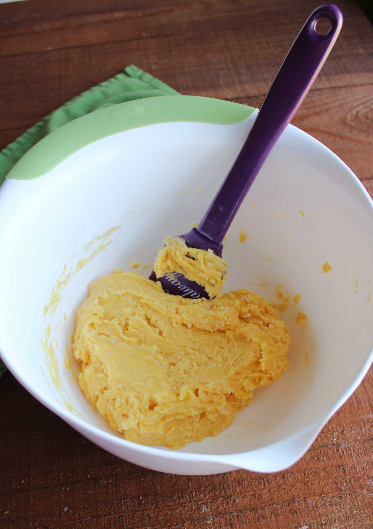 Mixing bowl with thick cake mix, butter, and egg mixture for crust.