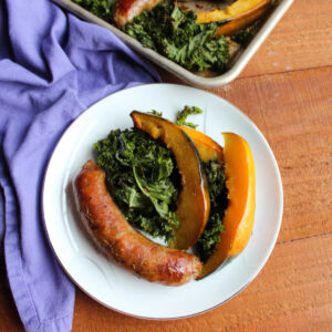 plate of roasted Italian sausage, acorn squash and kale ready to eat.