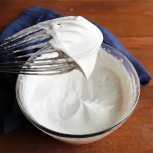 whisk filled with fluffy white whipped cream sweetened with maple syrup.
