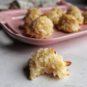 Chewy coconut macaroon with a bite missing showing the soft center.
