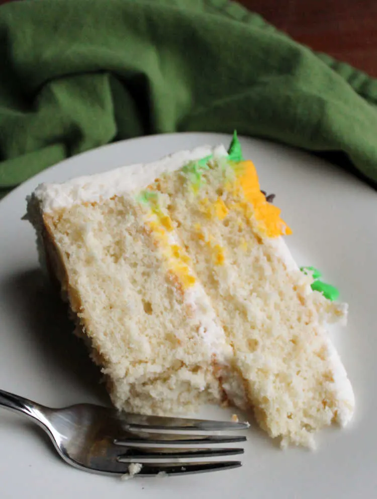 bite missing from slice of white layer cake.