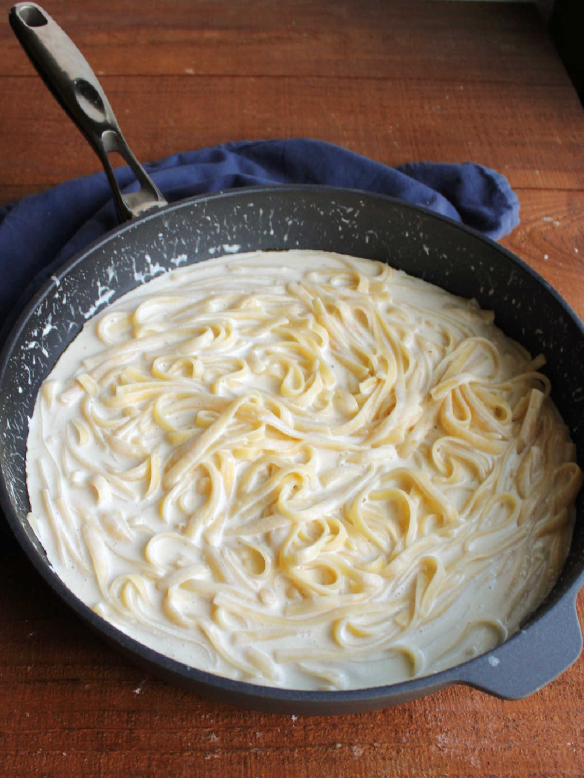 Pan of creamy fettuccine alfredo pasta with smooth creamy white sauce.