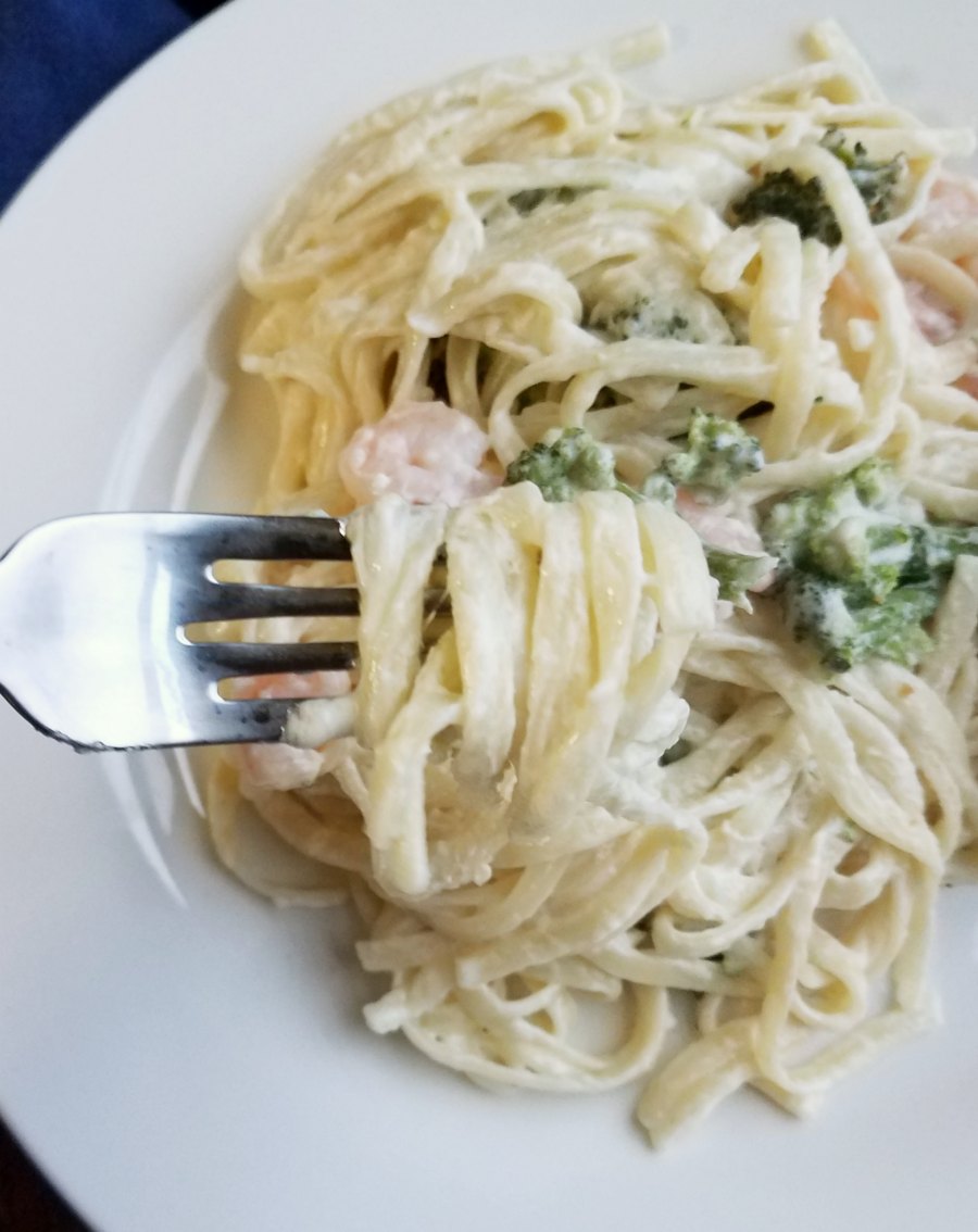 fork loaded with alfredo coated fettuccine noodles