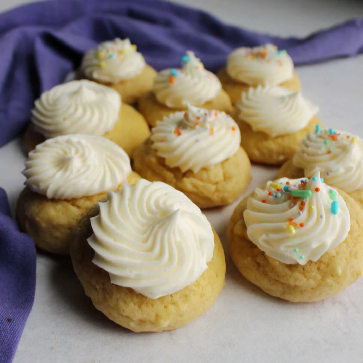 Soft and thick sour cream cookies topped with swirls of buttercream on top.