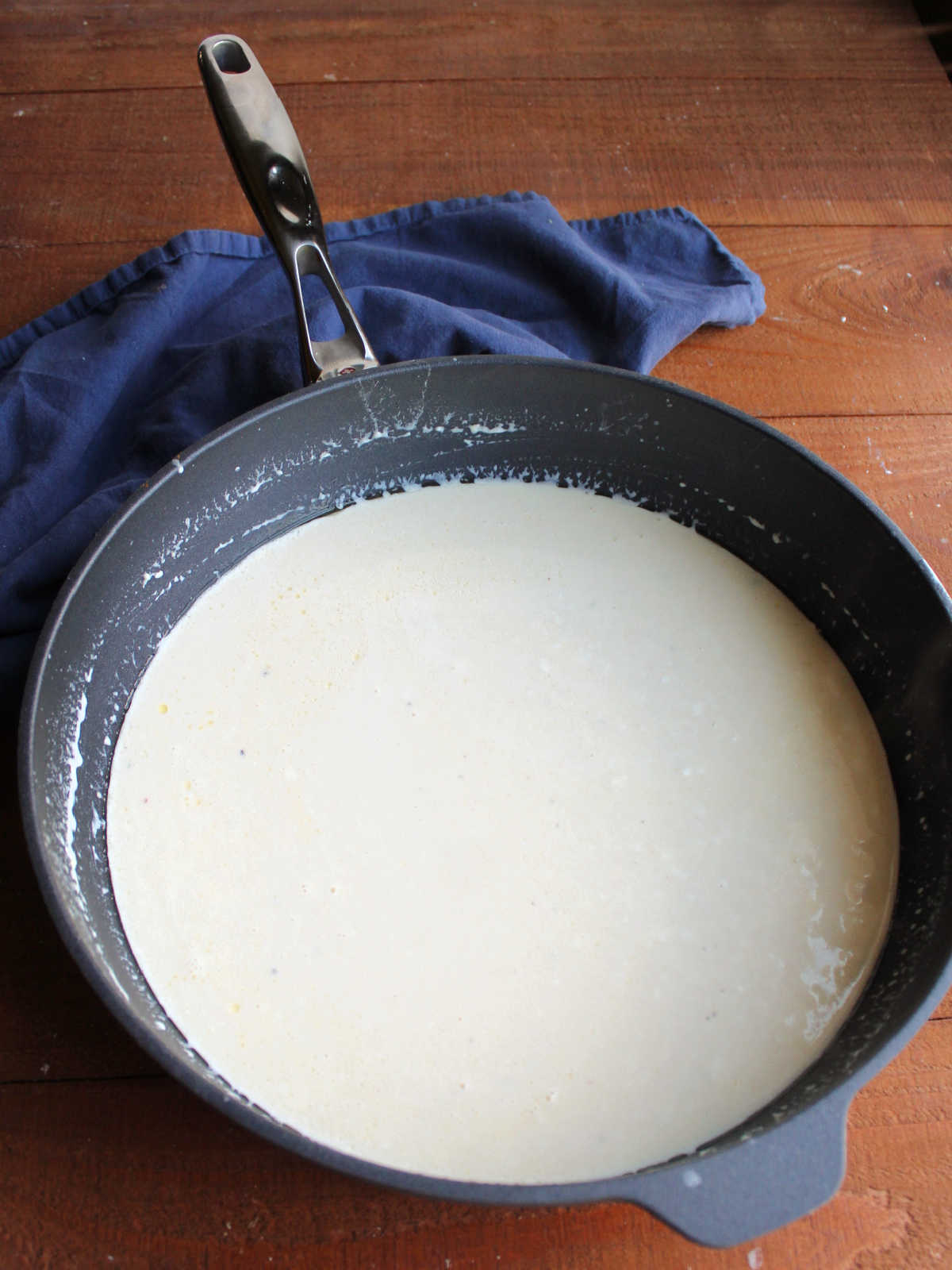 Large saute pan with creamy homemade alfredo sauce inside.