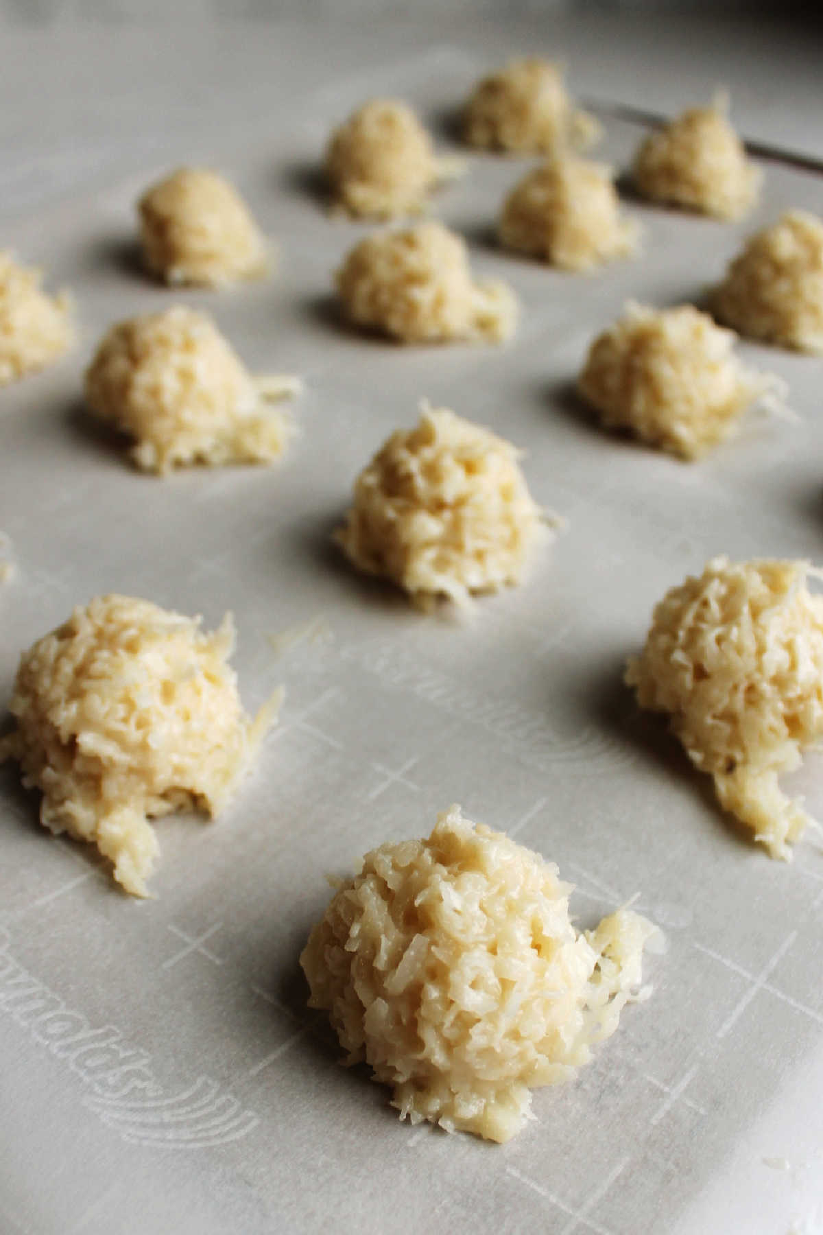 Scoops of condensed milk coconut macaroons ready to be baked.