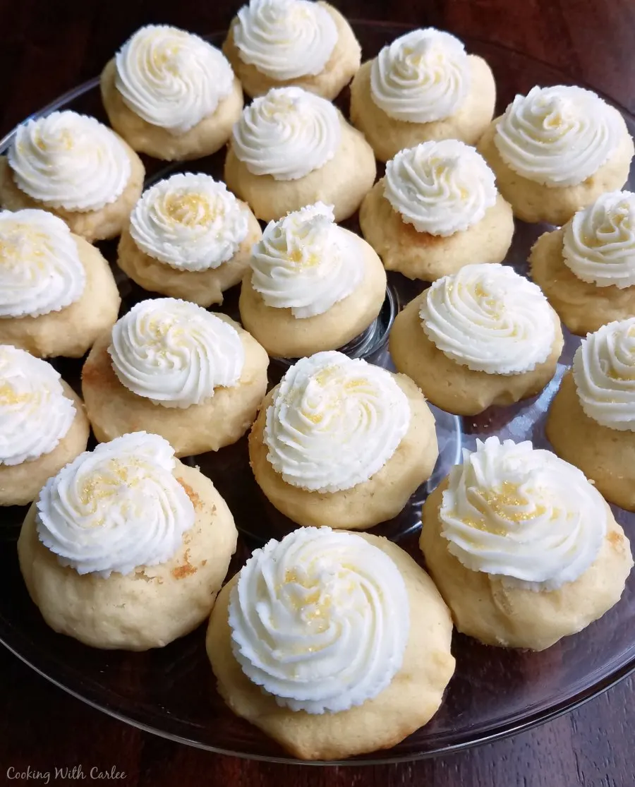 Plate of soft rounded sour cream cookies topped with buttercream frosting.