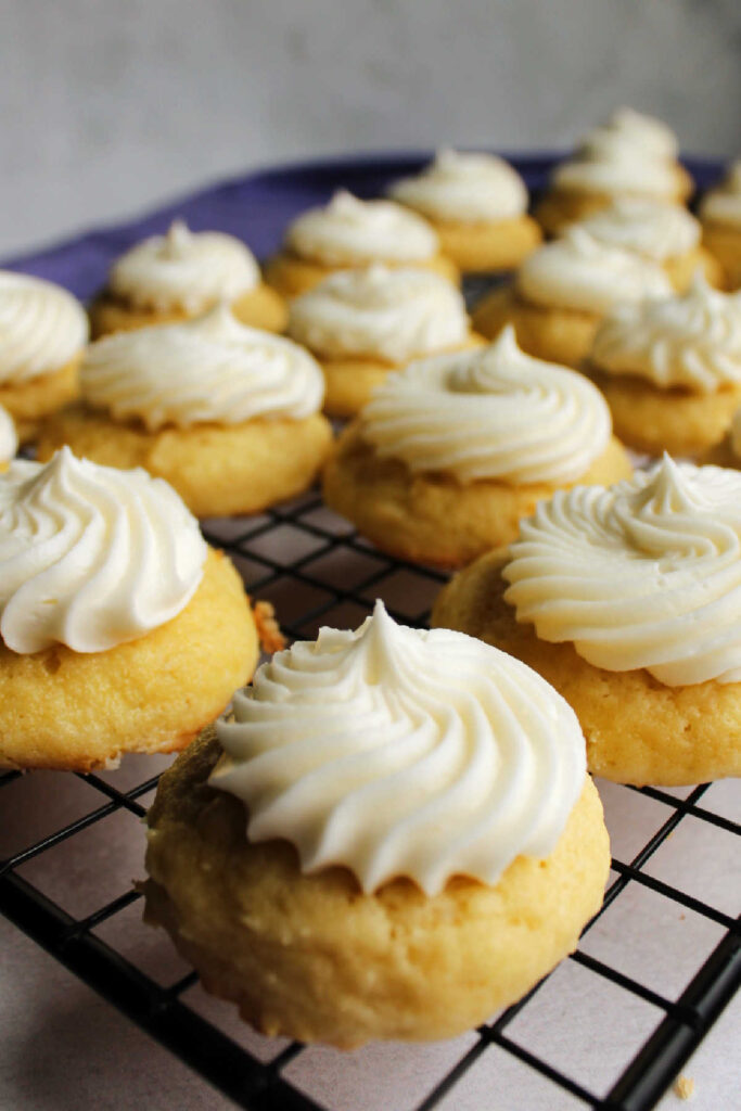 Thick vanilla sour cream cookies topped with swirls of bright white buttercream.