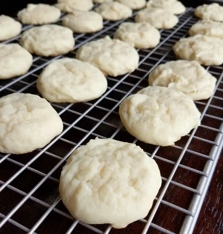 soft round sour cream cookies on cooling rack.