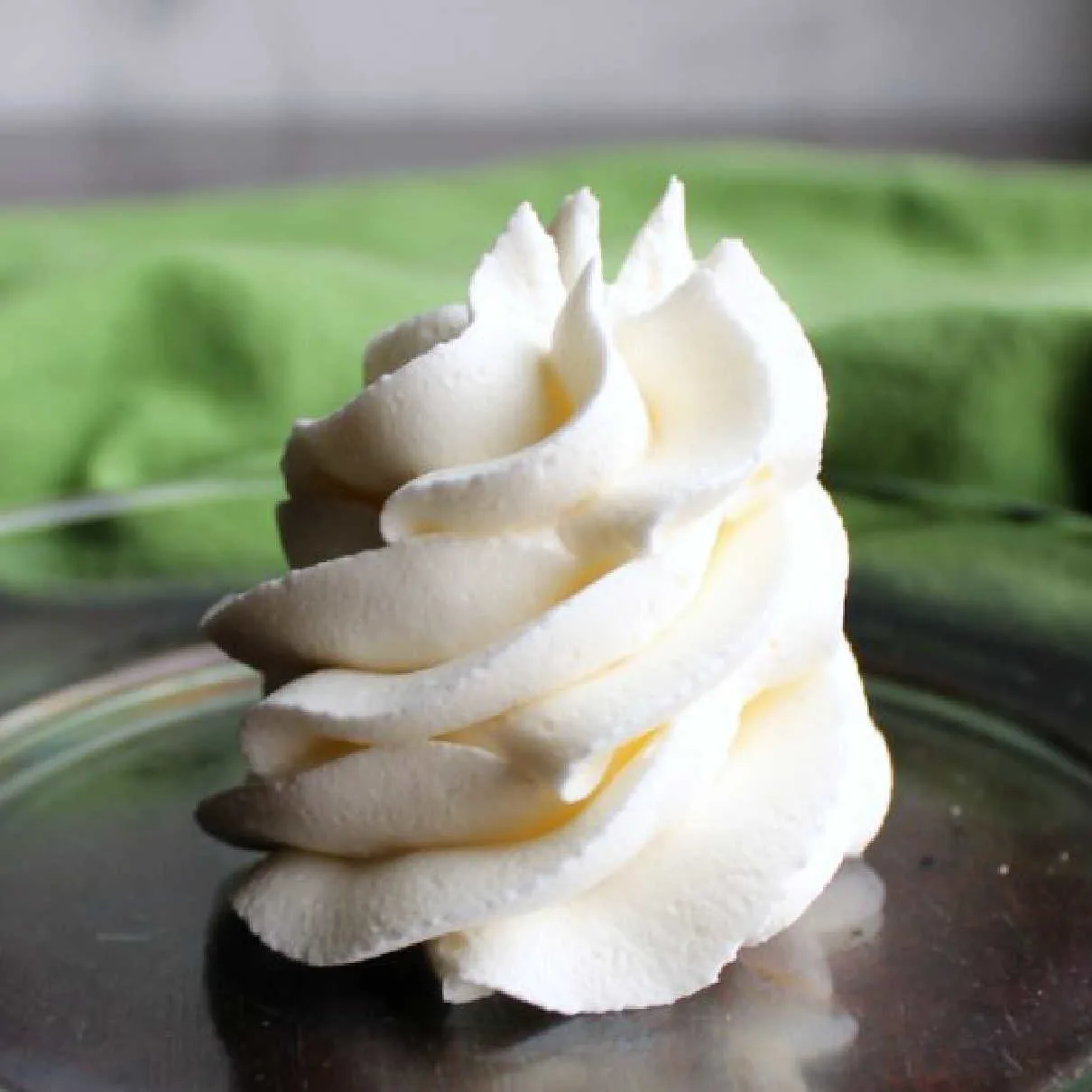 swirl of white classic American buttercream on plate.