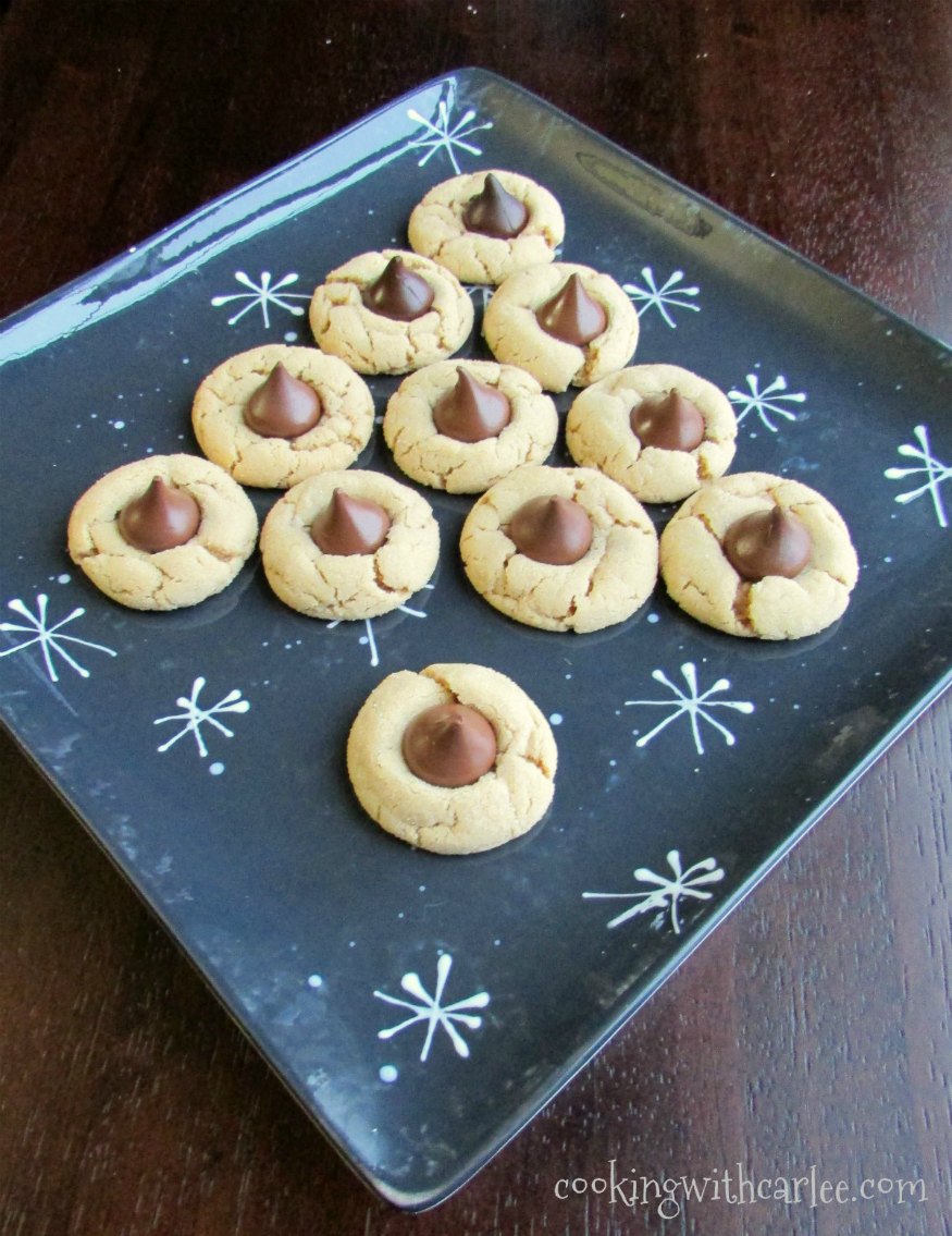 chew peanut butter blossom cookies topped with chocolate kisses arranged to look like Christmas tree.