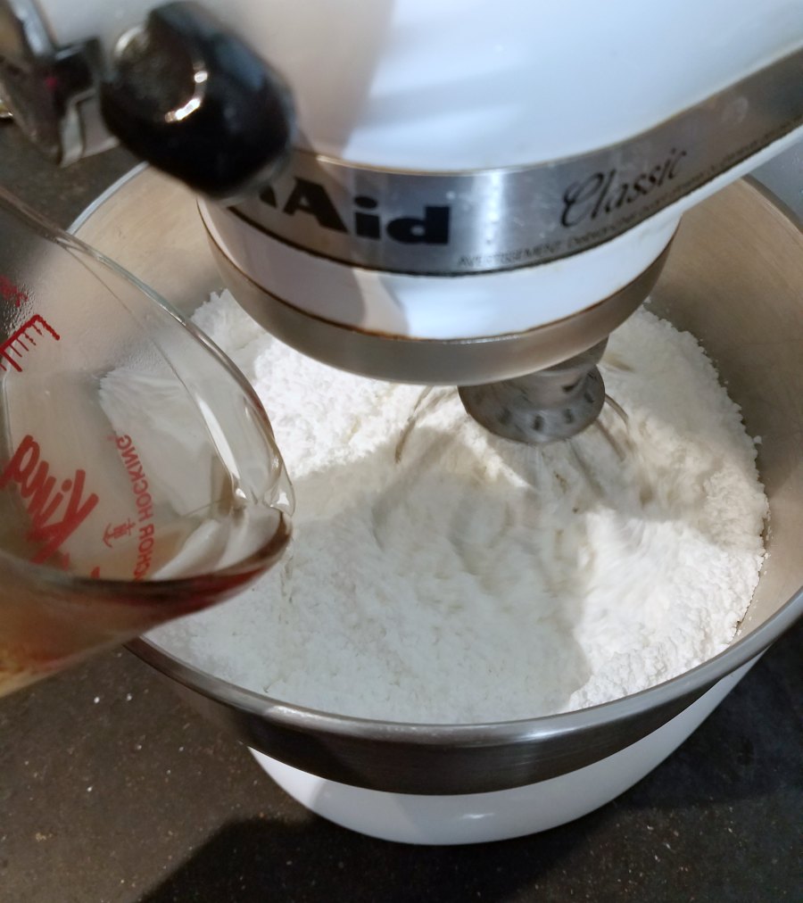 pouring warm water into sugar and meringue powder mixture.