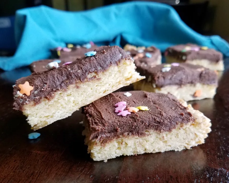 pile of soft sugar cookie bars with chocolate buttercream. 