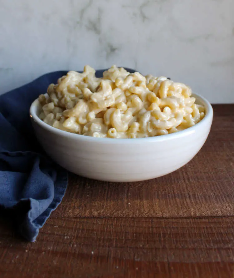 white serving bowl filled with creamy cheesy mac and cheese.
