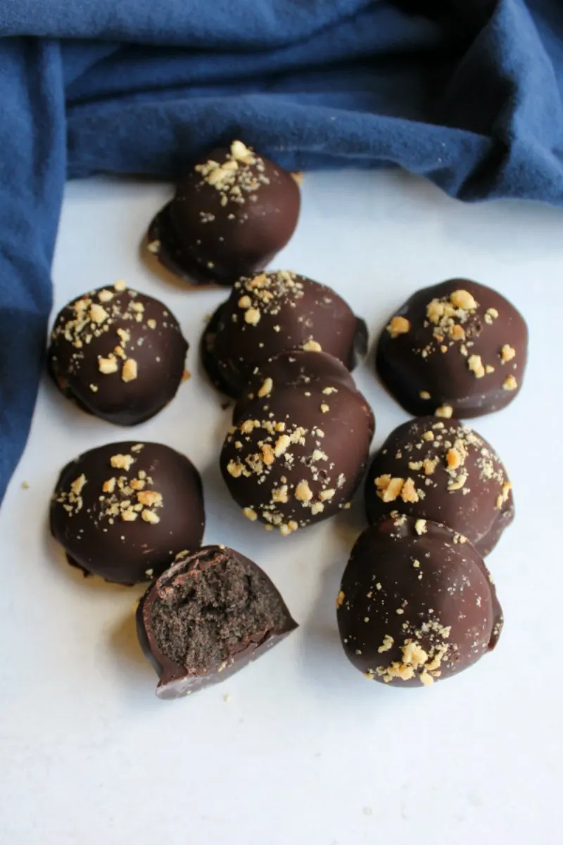 pile of chocolate peanut butter Oreo truffles with chopped peanuts on top