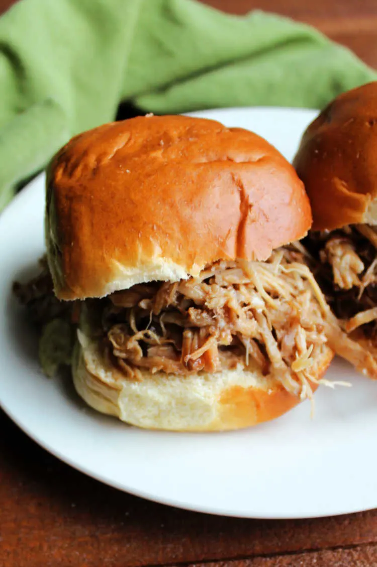 Asian style pineapple pulled pork sandwich on plate.