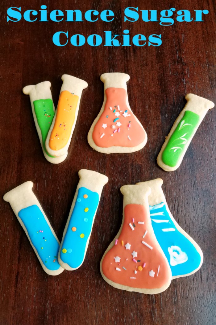 sugar cookies cut into shapes of test tubes and Erlenmeyer flasks decorated with royal icing and sprinkles.