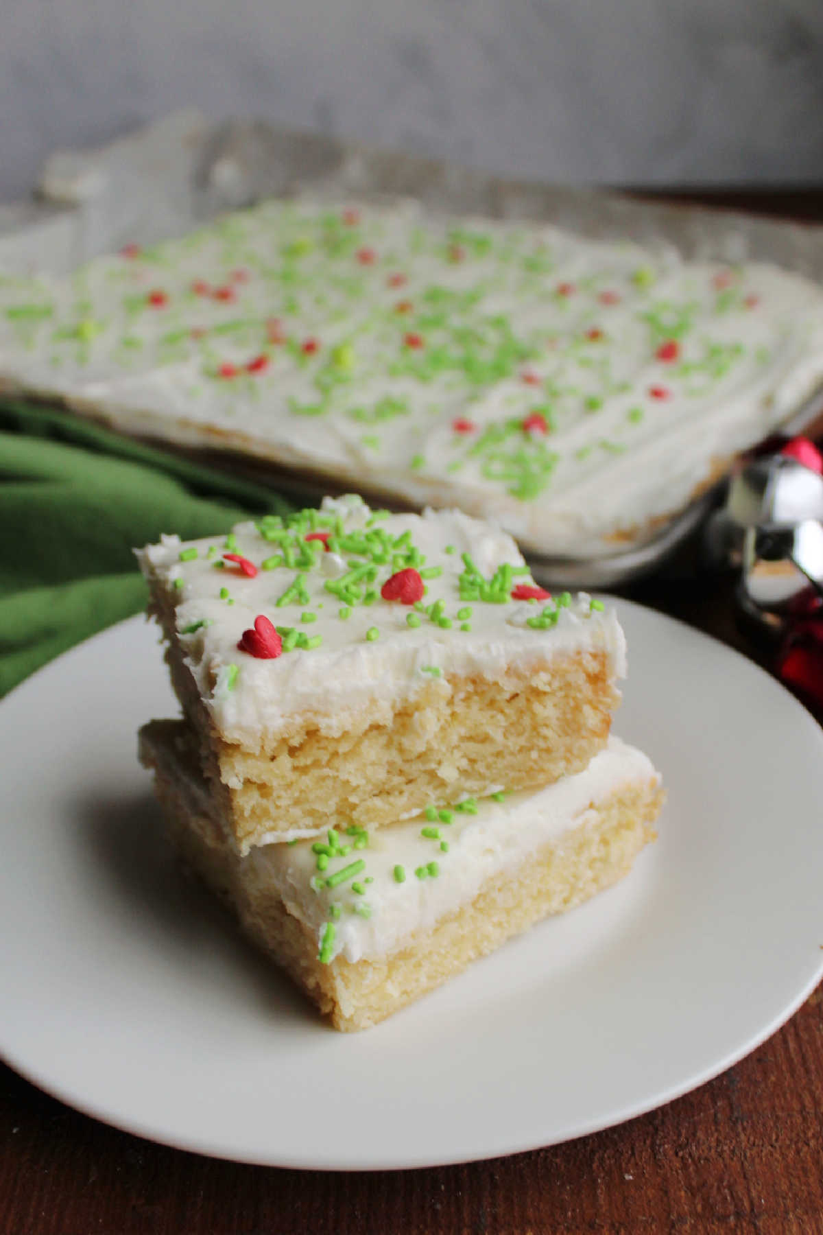 Plate with squares of soft sugar cookie bars with vanilla frosting on top.