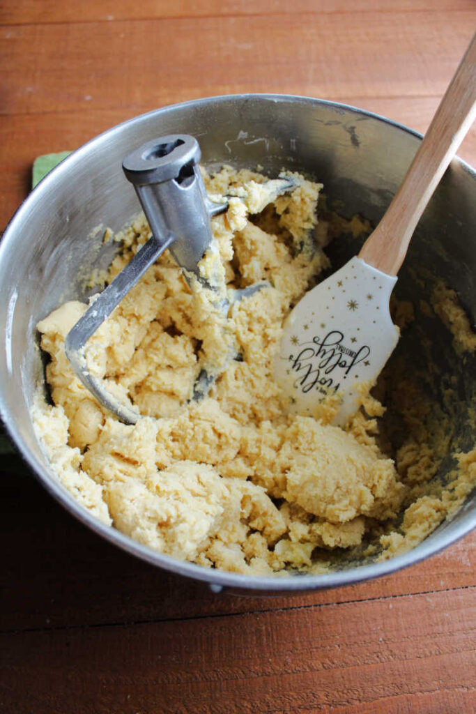 mixer bowl with paddle, sugar cookie dough and spatula.