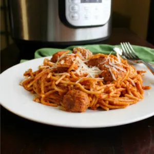 pile of spaghetti and meatballs on plate in front of instant pot.
